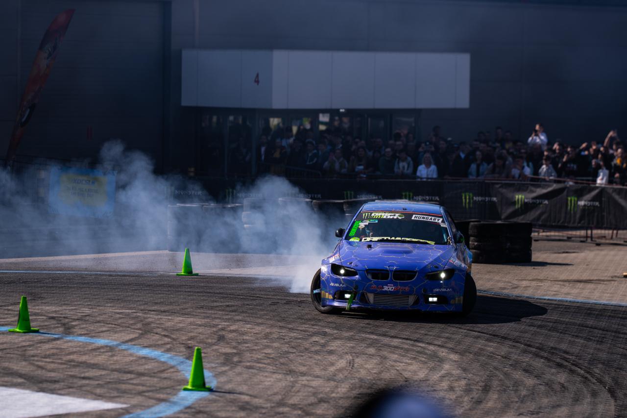 Blue BMW DriftWarrior Hungary race car drifting through cones at Monster Energy outdoor arena